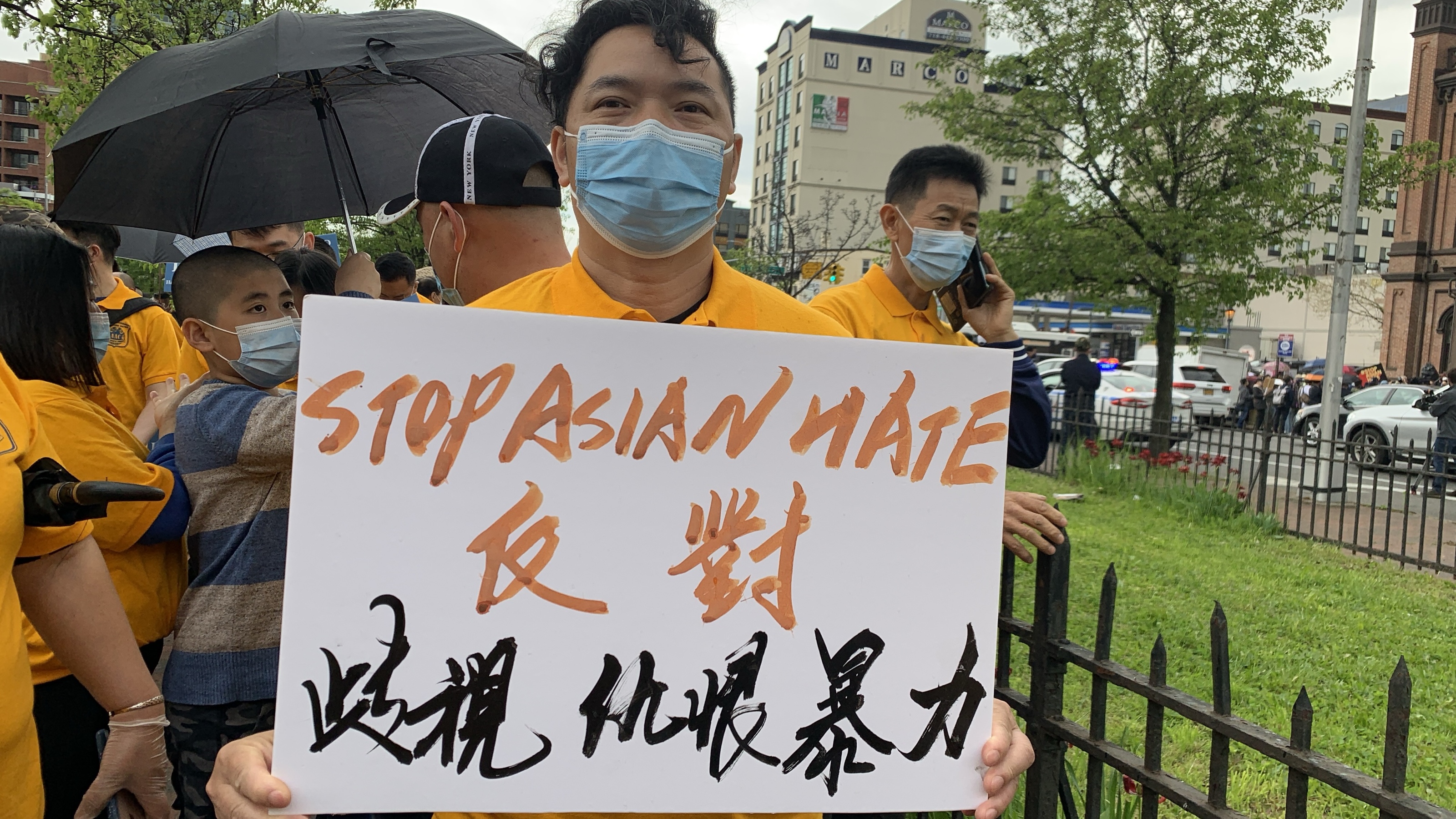 Liu Qiming holds a sign reading “STOP ASIAN HATE / Oppose discrimination, hatred and violence.”