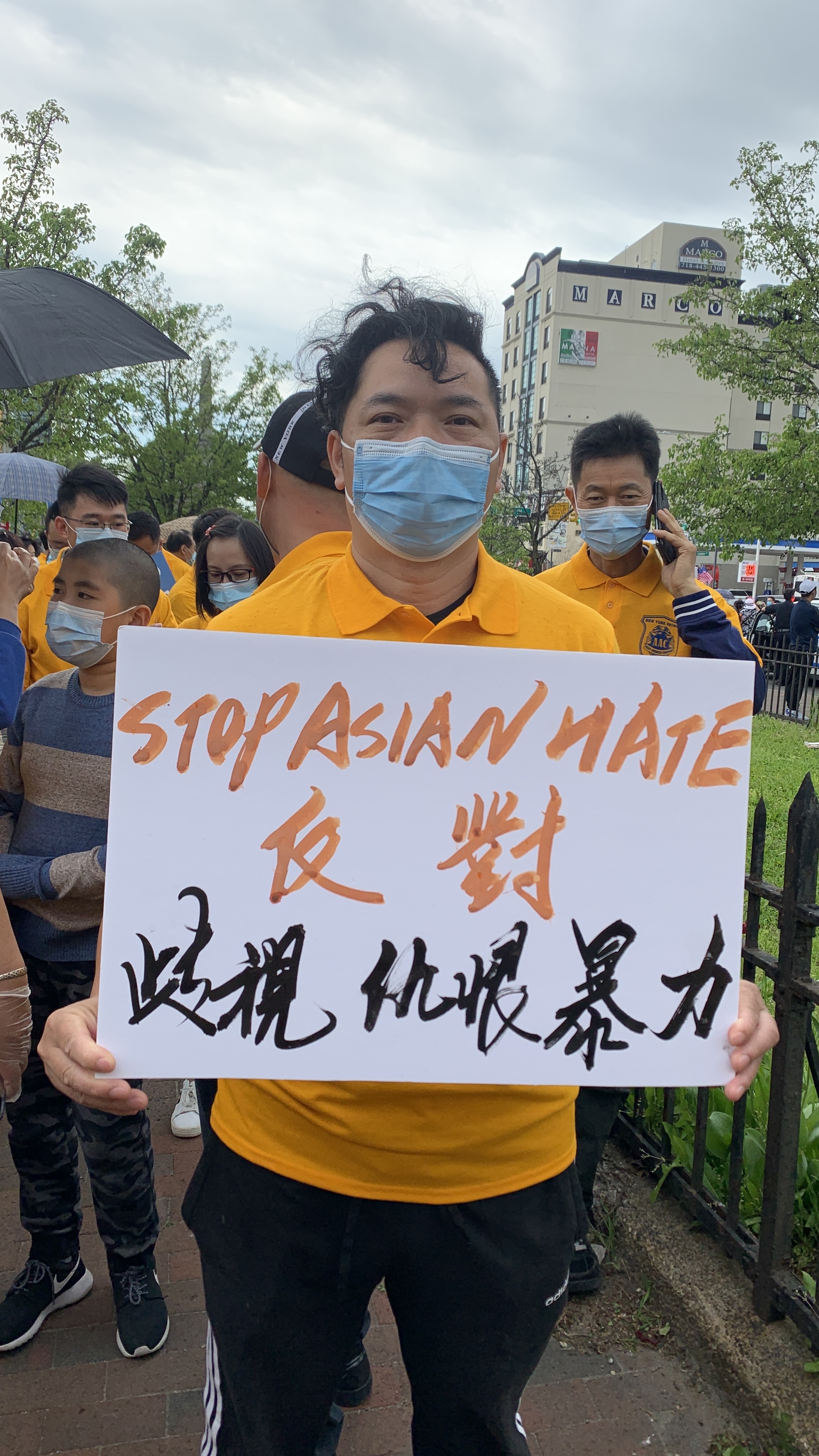 Another photograph of Liu Qiming holding the sign at the gathering.
