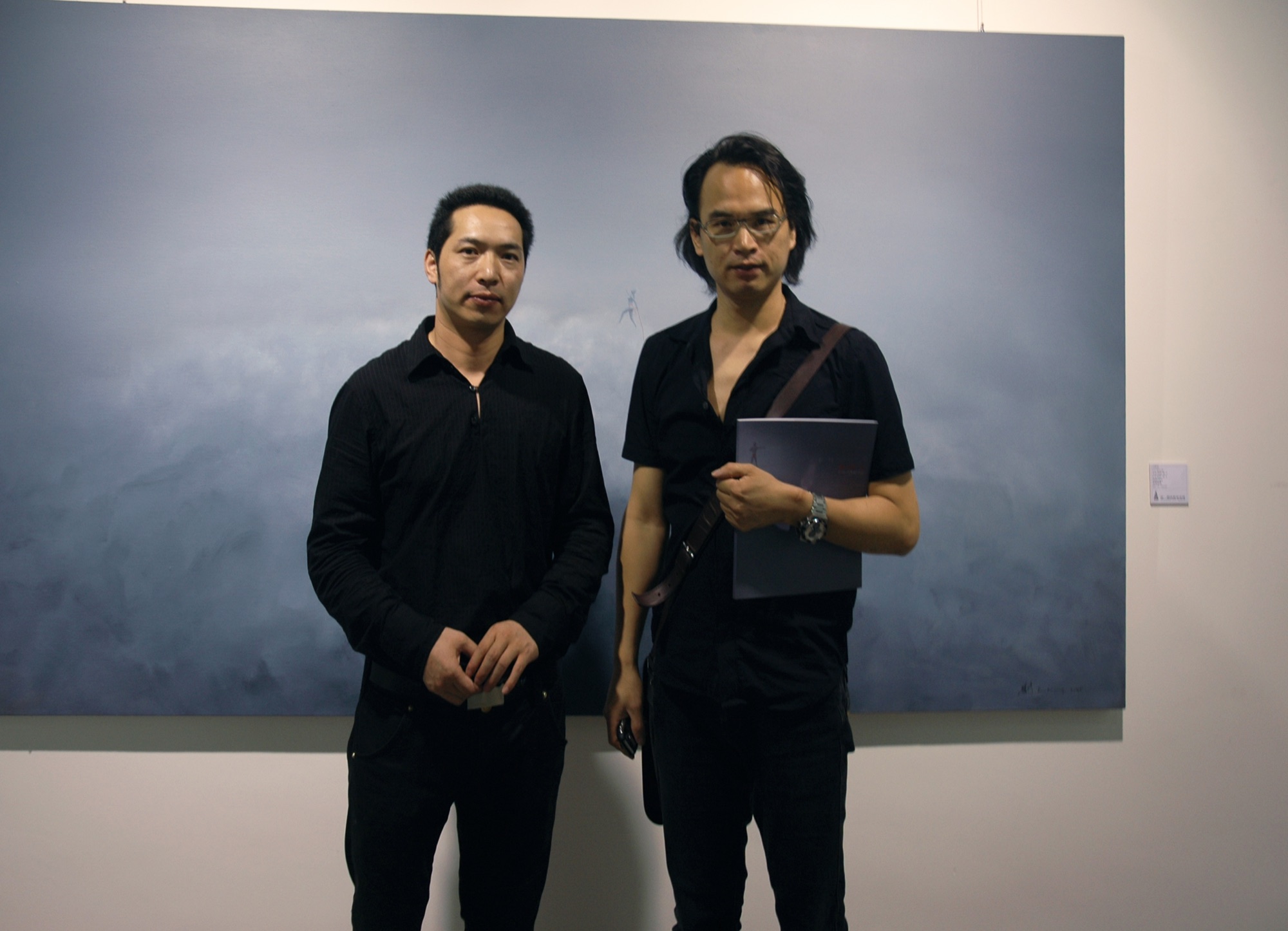 Two people posing in front of a painting at A Single Thread.