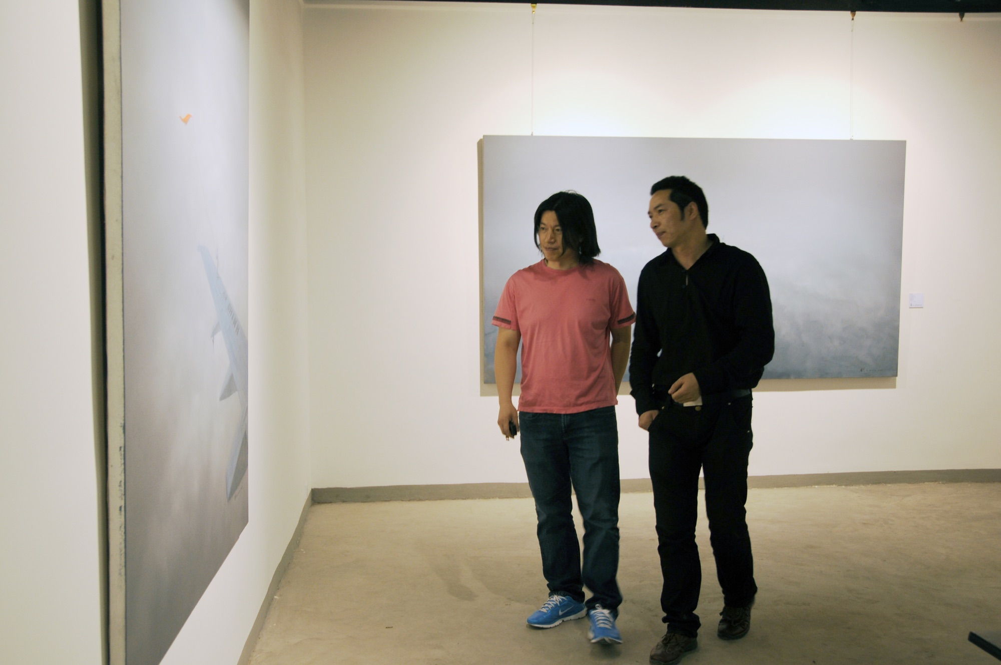 Two people viewing paintings at A Single Thread.