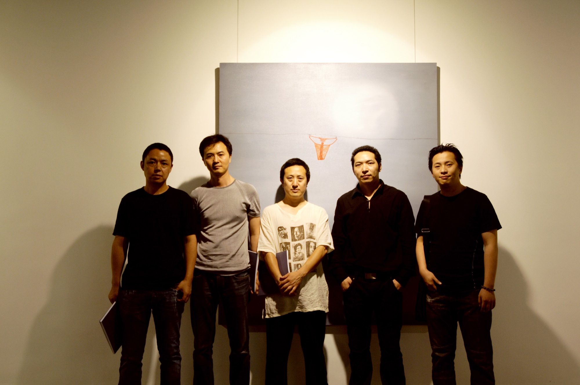 Five people posing in front of a painting at A Single Thread.