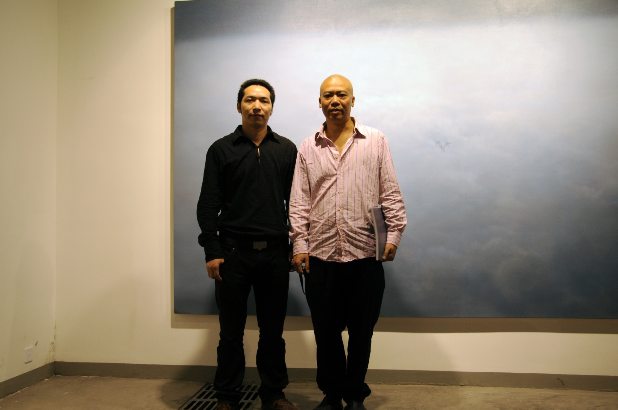 Two people posing in front of a painting at A Single Thread.