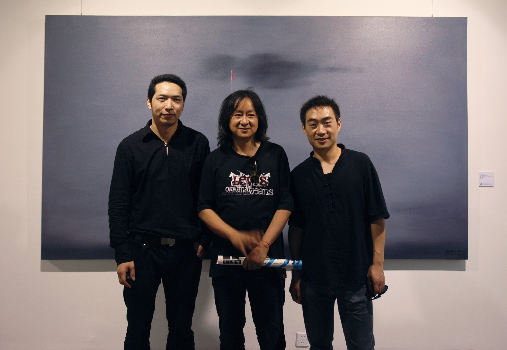 Three people posing in front of a painting at A Single Thread.